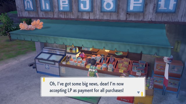 Une capture d’écran Pokémon Scarlet and Violet: The Teal Mask du joueur devant le magasin de Peachy. Le dialogue se lit comme suit : "Oh, j’ai de grandes nouvelles, ma chérie! J’accepte maintenant LP comme moyen de paiement pour tous les achats!"